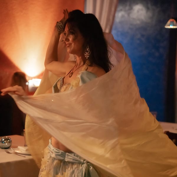 A belly dancer in a light blue and gold costume performs at Leila Restaurant.